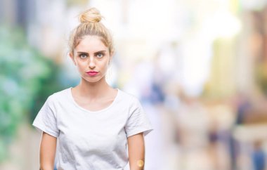 İzole arka plan üzerinde beyaz t-shirt giyen genç güzel sarışın kadın depresif ve kızgın ve korkmuş ağlıyor sıkıntı için endişeleniyorum. Üzgün ifade.