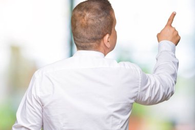 Orta yaş Arap zarif adam izole arka plan geriye doğru arkasında parmak eliyle işaret Posing