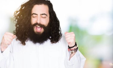 İsa Mesih silah ile başarı için heyecanlı giyinen adam zafer kutluyor gülümseyen kaldırdı. Kazanan kavramı.