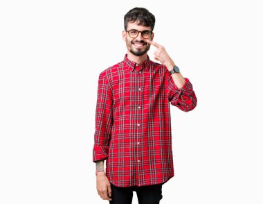 Genç yakışıklı adam gözlük izole üzerinde işaretleme için yüz ve burun, neşeli gülümseyerek el parmak ile arka plan