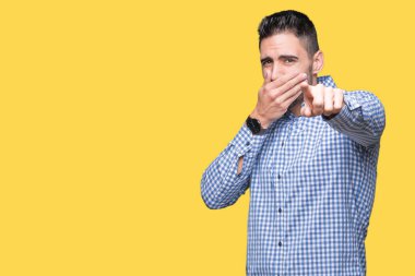 İzole genç yakışıklı adam arka plan sizin parmak el kamerasıyla ağzına, utanç ifadesi işaret eden gülme
