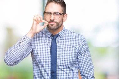 Young business man wearing glasses over isolated background mouth and lips shut as zip with fingers. Secret and silent, taboo talking clipart