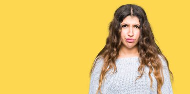 Kış kazak şüpheci ve sinir, papatyanın üzgün sorunu nedeniyle giyen genç güzel kadın. Negatif kişi.