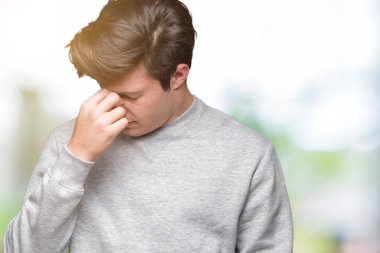 Genç yakışıklı sportif adam giyen Sweatshirt üzerinde izole arka plan yorgun sürtünme burun ve gözleri hissi yorgunluk ve baş ağrısı. Stres ve hayal kırıklığı kavramı.