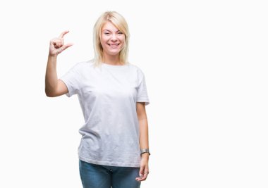 İzole arka plan gülümseyen ve süre seyir ve kamera boyutu işaret parmaklarıyla yapıyor el ile kendinden emin eller üzerinde beyaz t-shirt giyen genç güzel sarışın bir kadın. Ölçü kavramı.