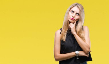 Kadın el ile arka plan üzerinde izole genç güzel sarışın ve mavi gözleri soru, dalgın ifade düşünmeye çene. Düşünceli yüzüyle gülümsüyor. Şüphe kavramı.