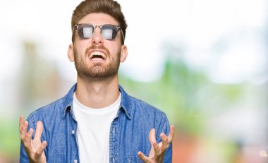 Denim ceket ve deli deli bağırarak ve agresif ifade ve silah kaldırdı bağırmaya giyen genç yakışıklı zarif adam. Hayal kırıklığı kavramı.