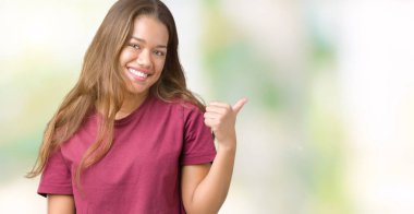 Genç güzel esmer kadın arıyorum ve başparmak yanında yukarıyı mutlu yüz ile gülümseyen izole arka plan üzerinde.