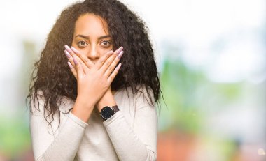 Kıvırcık saçlı rahat kazak ağız hata için elleriyle kapsayan şok giyen genç güzel kız. Gizli kavramı.