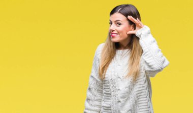 Genç güzel kadın bir işitme söylenti ya da dedikodu için dinleme kulak üzerinde el ile gülümseyen izole arka plan üzerinde rahat beyaz kazak. Sağırlık kavramı.