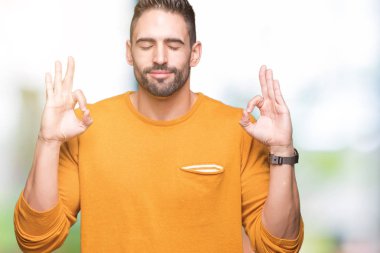 Yakışıklı delikanlı izole arka plan üzerinde dinlenmek ve gülümseyen gözlerle parmak ile meditasyon jest yapıyor kapalı. Yoga kavramı.