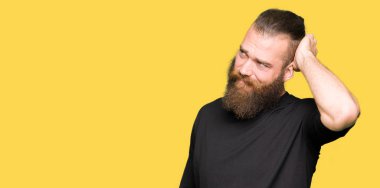 Genç sarışın adam rahat t-shirt giyen yanıltır ve soru hakkında merak ediyorum. Şüphe, kafasına el ile düşünme ile belirsiz. Dalgın kavramı.