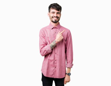 Yakışıklı delikanlı izole arka neşeli bir gülümseme ile yüz el ve parmak kadar mutlu ve doğal ifade yüzünde yanında işaret içinde pembe gömlek giymiş