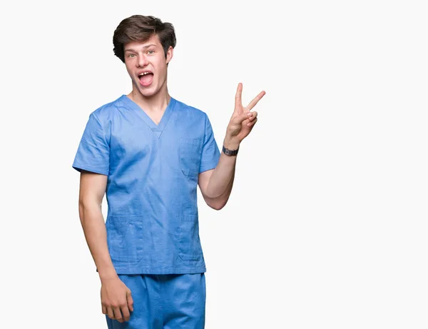 Νεαρός Γιατρός Φορώντας Ιατρική Στολή Πέρα Από Απομονωμένο Υπόβαθρο Χαμογελώντας — Φωτογραφία Αρχείου