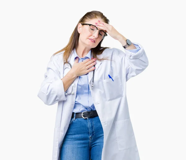 上医療のコートを着て中年中高年医師女性バック グラウンドを分離した病気 インフルエンザ ウイルスの病気のための額に触れる — ストック写真