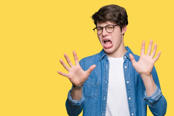 Homem Bonito Jovem Usando Óculos Sobre Fundo Isolado Com Medo — Fotografia de Stock