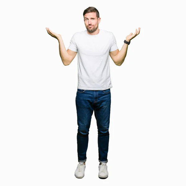 Schöner Mann Lässigem Weißem Shirt Mit Ratlosem Und Verwirrtem Gesichtsausdruck — Stockfoto