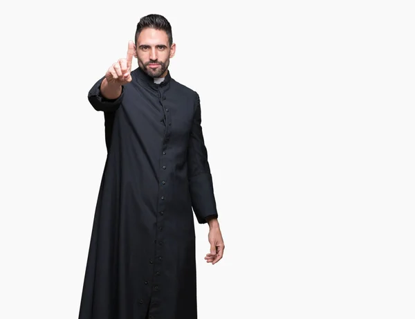 Young Christian priest over isolated background Pointing with finger up and angry expression