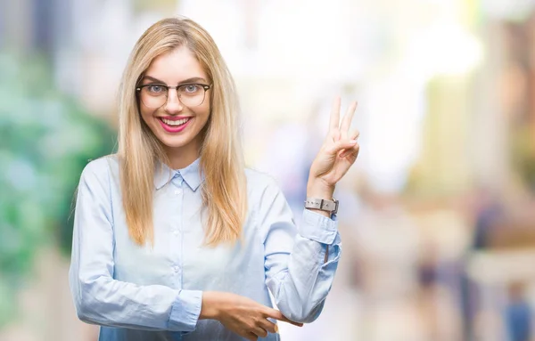 Young beautiful blonde business woman wearing glasses over isolated background smiling with happy face winking at the camera doing victory sign. Number two.