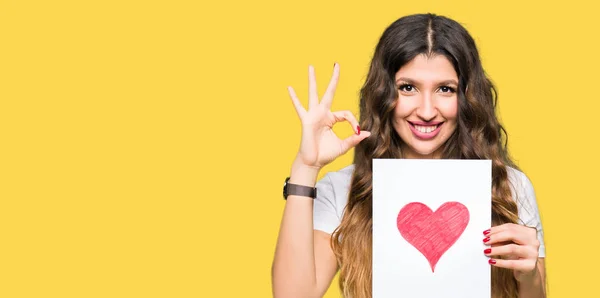 Joven Mujer Adulta Sosteniendo Tarjeta Con Corazón Rojo Haciendo Signo — Foto de Stock