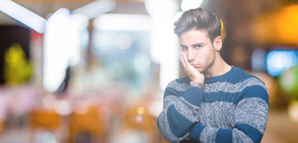 Young handsome man over isolated background thinking looking tired and bored with depression problems with crossed arms.