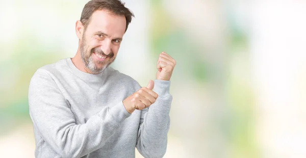 英俊的中年男子穿着一件运动衫在孤立的背景上 用手和大拇指指着后面 面带微笑自信 — 图库照片