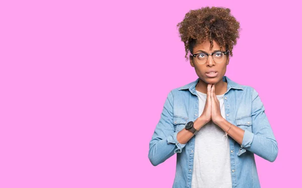 美しい若いアフリカ系アメリカ人女性の懇願するような非常に感情的なおよび心配の顔希望表現とともに手で祈って分離の背景にメガネを着用します 赦しを乞います 宗教概念 — ストック写真