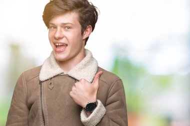 Genç yakışıklı adam el ile jest kadar mutlu başparmak yapıyor izole arka plan üzerinde kış ceket giyiyor. Başarı gösteren kameraya bakarak ifadeyi onaylama.