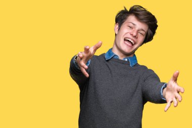 İzole arka planda genç yakışıklı zarif adam sarılmak için açık kollar ile gülümseyen kamera bakıyor. Mutluluğu kucaklayan neşeli ifade.