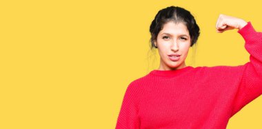 Kırmızı kazak ve topuz güçlü kişi kol kas, kendinden emin ve güç gurur gösterilen giyen genç güzel kadın