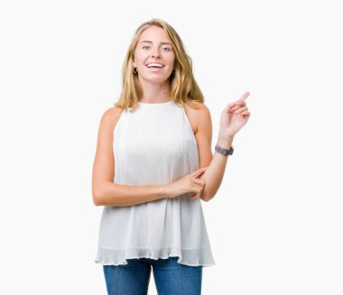 Yüzünde kocaman bir gülümseme ile izole arka plan üzerinde güzel genç zarif kadın kameraya bakarak yan el ve parmak ile işaret.