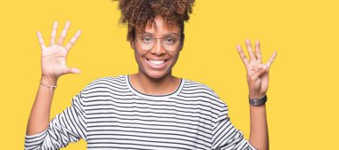 Güzel genç Afro-Amerikan kadın gözlük gösterilen ve parmakları ile işaret izole arka plan üzerinde dokuz kendinden emin ve mutlu gülümseyerek iken numara.