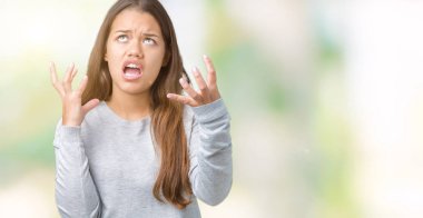 Üzerinde kazak giyen genç güzel esmer kadın arka plan deli izole ve deli bağırarak ve agresif ifade ve silah kaldırdı bağırıyor. Hayal kırıklığı kavramı.