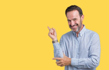 Kameraya bakarak yan el ve parmak ile işaret eden yakışıklı orta yaş zarif komuta sizde yüzünde kocaman bir gülümseme ile izole arka plan üzerinde.