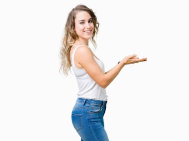 İzole arka plan üzerinde sarışın güzel genç kadın el ve reklam mutlu ve kendinden emin gülümseyen sunulması avuç, yanında işaret