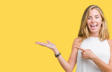 Güzel genç zarif kadın üzerinden hayran ve el ile sunulması ve parmak ile işaret ederken kameraya gülümseyen izole arka plan.