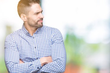 İkna ve kendine güvenen genç yakışıklı adam tarafına silahlarla seyir gülümseyen izole arka plan üzerinde çarpı işareti