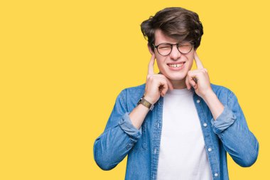Yüksek sesle müzik gürültü rahatsız ifade parmaklarıyla kulaklarıyla kapsayan izole arka plan üzerinde gözlük takan yakışıklı delikanlı. Sağır kavramı.