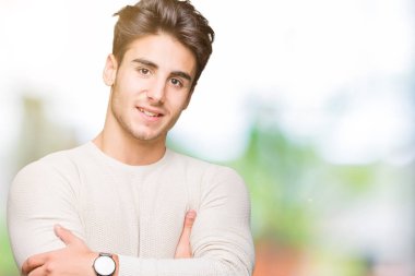 İzole arka plan mutlu yüz çapraz silah kameraya bakarak ile gülümseyen genç yakışıklı adam. Olumlu bir kişi.