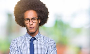 Gözlük şüpheci ve sinir, onaylamayan ifade yüz çapraz kollu giyiyor afro saçlı genç Afro-Amerikalı iş adamı. Negatif kişi.