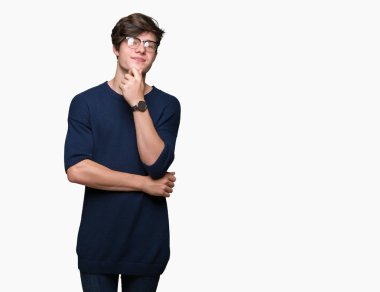 Emin çapraz kollar ve çeneme kaldırdı el ile gülümseme ile kameraya bakarak izole arka plan üzerinde gözlük takan yakışıklı delikanlı. Pozitif düşünce.