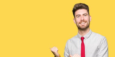 Genç yakışıklı iş arkasından el ve kadar başparmak ile işaret emin gülümseyen adam