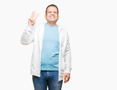 Gösterilen arka plan üzerinde sweatshirt giyen orta yaş Arap adam izole ve parmakları ile işaret kendinden emin ve mutlu gülümseyerek iken üçüncü.