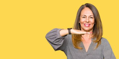 Güzel orta yaş iş kadını ile el hareketi büyük ve büyük boy işaret, ölçü birimi sembol gösteren eller. Kameraya bakarak gülümsüyordu. Ölçüm kavramı.