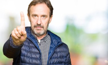Orta yaş yakışıklı adam giyen kış ceket işaret parmağını ve kızgın ifade ile