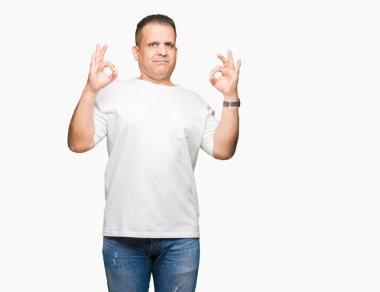 Orta yaş Arap adam wearig beyaz t-shirt üzerinde izole arka plan Relax ve gözleri ile gülümseyen meditasyon jest parmaklar ile kapalı. Yoga konsepti.