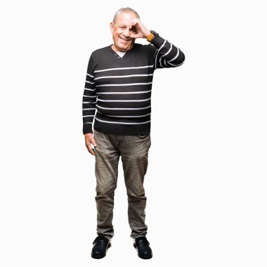 El gülümseyen, göz mutlu yüz ile parmaklarla görünümlü ok jest yapıyor kış çizgili kazak giyen yakışıklı kıdemli adam.