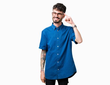 Genç yakışıklı adam gözlük izole üzerinde bir parmak, harika bir fikir ya da düşünce, iyi hafıza ile baş gösteren gülen arka plan