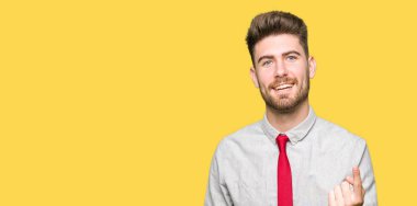 Genç yakışıklı iş adamı Beckoning gel burada mutlu ve gülümseyerek el davet ile jest