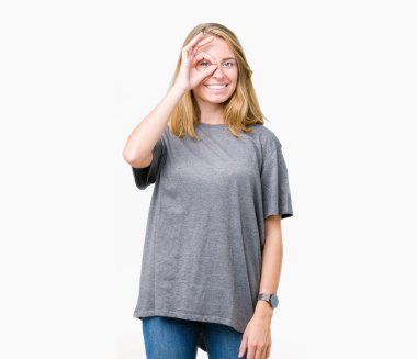 Gülümseyen, parmakları ile mutlu yüz üzerinden seyir göz el ile ok jest yapıyor izole arka plan üzerinde büyük boy rahat t-shirt giyen güzel genç kadın.
